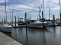 Sailboats next to a wooden pier docked in the harbor with water Royalty Free Stock Photo