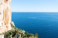 Sailboats and orange brown vertical rock