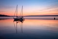 sailboats reflection on calm water at dawn