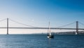 Sailboats with white sails on the Tagus River, 25 of April Bridge, Lisbon, Portugal Royalty Free Stock Photo