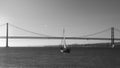 Sailboats with white sails on the Tagus River, 25 of April Bridge, Lisbon, Portugal - monochrome Royalty Free Stock Photo