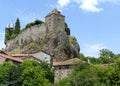 The Sailhant castle on top of a rocky outcrop overlooking the houses of the hamlet Royalty Free Stock Photo