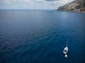 Sailing boat anchored in turquoise blue sea. A small watercraft, boat. Sunny summer day. Rocks, steep stone coasts of the sea, Royalty Free Stock Photo