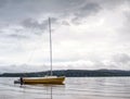 Sailing boat anchoring next to a buoy in the calm water of lake