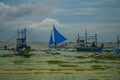 Sailing boat with a blue sail on a background of clouds , Boracay island, Philippines Royalty Free Stock Photo