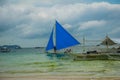 Sailing boat with a blue sail on a background of clouds , Boracay island, Philippines Royalty Free Stock Photo