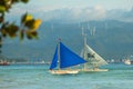 Sailing boat with a blue sail on a background of clouds , Boracay island, Philippines Royalty Free Stock Photo