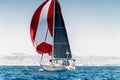 Sailing boat on a calm water with red sail during the regatta Royalty Free Stock Photo