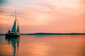 Sailing boat floats on the lake at sunset Royalty Free Stock Photo