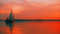 Sailing boat floats on the lake at sunset Royalty Free Stock Photo