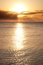 Sailing boat on horizon bathed in sun's rays