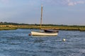 A sailing boat moored in the River Glaven, Norfolk at sunset