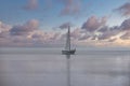 Sailing boat in morning dusk on a flat calm sea Royalty Free Stock Photo