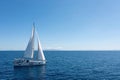 Sailing boat with open white sails, blue sky and rippled sea background Royalty Free Stock Photo