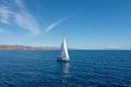 Sailing boat with open white sails, blue sky and rippled sea background Royalty Free Stock Photo