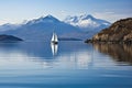 sailing boat passing through calm waters, with majestic mountains in the background