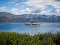 Sailing boat passing a shore of Hvar island, Croatia on sunny summer day