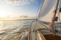 Sailing boat sailing fast into the sunset on choppy sea with slightly tilted horizon Royalty Free Stock Photo