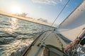 Sailing boat sailing fast into the sunset on choppy sea with tilted horizon Royalty Free Stock Photo