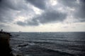 Sailing boat and a ship in the distance on a cloudy day Royalty Free Stock Photo