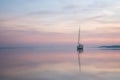 a sailing boat at sunset on a quiet lake