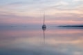 a sailing boat at sunset on a quiet lake