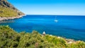A sailing boat into the turquoise Mediterranean Sea, at San Vito Royalty Free Stock Photo