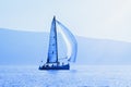 Sailing boat on water, blue tinting, silhouettes. Travel concept