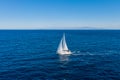 Sailing boat with white sails, cloudy sky and rippled sea background Royalty Free Stock Photo