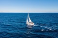 Sailing boat with white sails, cloudy sky and rippled sea background Royalty Free Stock Photo