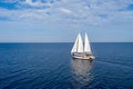 Sailing boat with white sails in the open sea, cloudy blue sky Royalty Free Stock Photo