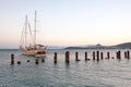 Sailing boat yacht, the ocean and the sunset. Bodrum port, Turkey. Breakwaters with steel posts.