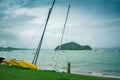 Sailing boats, catamarans, and kayaks at an empty beach by the sea. Stormy day