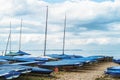 Sailing boats covered and moored on a shingle beach in Whitstable, Kent UK