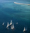 Group sailing boats and lighthouse at the sea