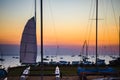 Sailing boats parked on trailers by the sea at sunset