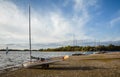 Sailing boats line up on the shore getting ready to launch on a sunny autumn day in England, UK