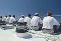 Sailing crew sitting on side of yacht on ocean back view Royalty Free Stock Photo