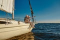 Sailing. Happy retired family couple sitting on the side of a sail boat or yacht deck floating in a calm blue sea Royalty Free Stock Photo