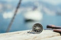 Sailing: nautical compass on wooden dock pier. Sailing boats in the background