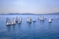 Sailing regatta or a group of small water racing boats in the Mediterranean, a panoramic view with blue mountains on a horizon Royalty Free Stock Photo