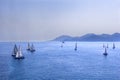 Sailing regatta or a group of small water racing boats in the Mediterranean, a panoramic view with blue mountains on a horizon Royalty Free Stock Photo