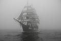 A sailing ship is sailing at full speed in the fog at sea Royalty Free Stock Photo