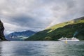 Sailing ship on a Norway fjord with mountains behind and rainbow and clouds above Royalty Free Stock Photo