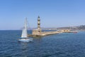 A sailing ship passes the old lighthouse and sails towards the port of Chania, Crete Royalty Free Stock Photo