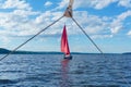 Sailing small yacht with red sails, visible from another boat through the rigging detail Royalty Free Stock Photo