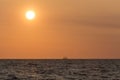 Sailing tallship on horizon and large sun