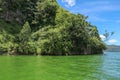 Sailing a traditional fishing boat from the village of Trunyan to a unique cemetery. High mountains covered with dense tropical Royalty Free Stock Photo