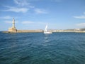 Sailing White Yacht near the Lighthouse at the Old Venetian Harbour of Chania, Crete Island, Greece Royalty Free Stock Photo