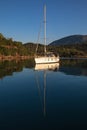 A sailing yacht at anchor in a quiet harbor on the coast of the Aegean Sea. Royalty Free Stock Photo